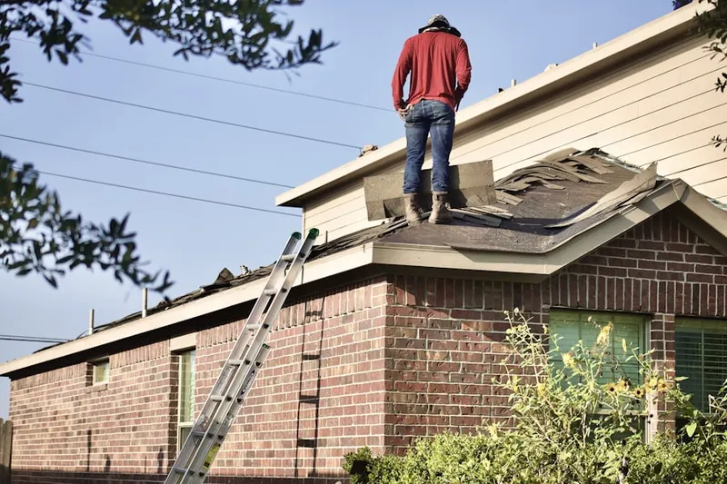 Professional roofer working on a residential roof in Clemens and Munsinger Gardens